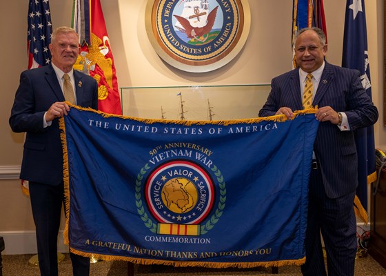 VWC Dir. Peter M. Aylward, presented the Commemorative flag to SecNav Carlos Del Toro