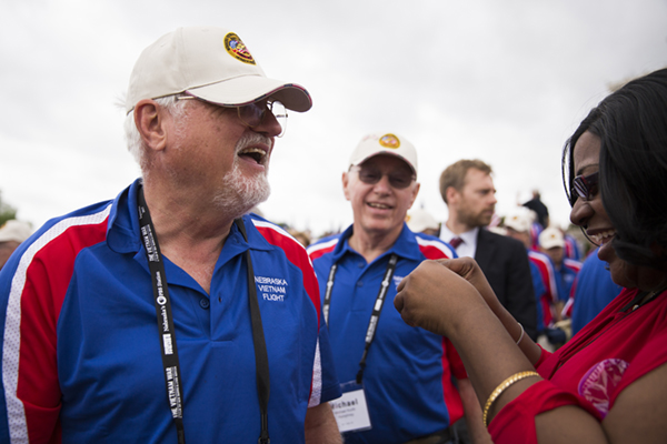 A Vietnam Veteran receives his Vietnam Veteran lapel pin from Vietnam War Commemoration staff.