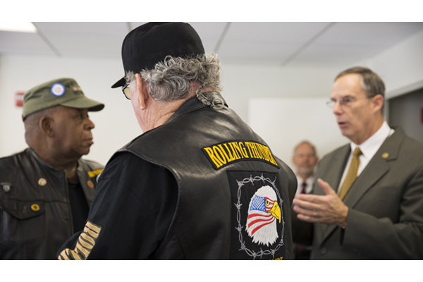 Bubba Owens and Walt Sides listen to James T. Jackson describes the symbolism of the lapel pin.