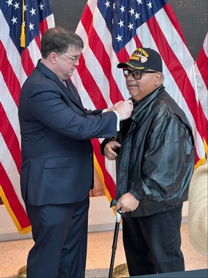 Former VA Secretary the Honorable Robert L. Wilke pins a Vietnam Veteran