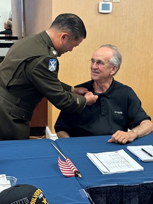LTC James Tom pins Vietnam veteran Retired U.S. Army Staff Sergeant James M. &#8220;Mike&#8221; Holden.