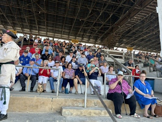 Photo of people in the grandstands at the fair.