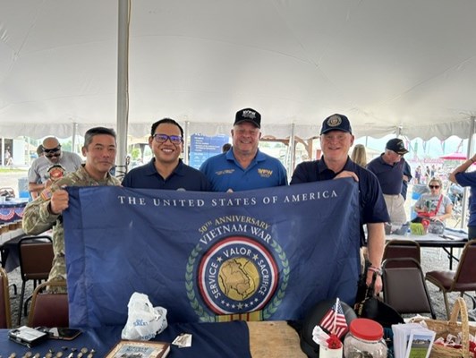 VWC staff and VVA members hold a Commemorative Flag. 