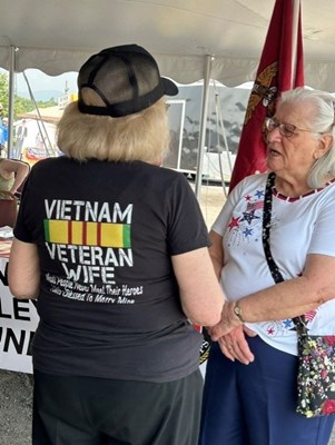 Two women hold a conversation at the fair.