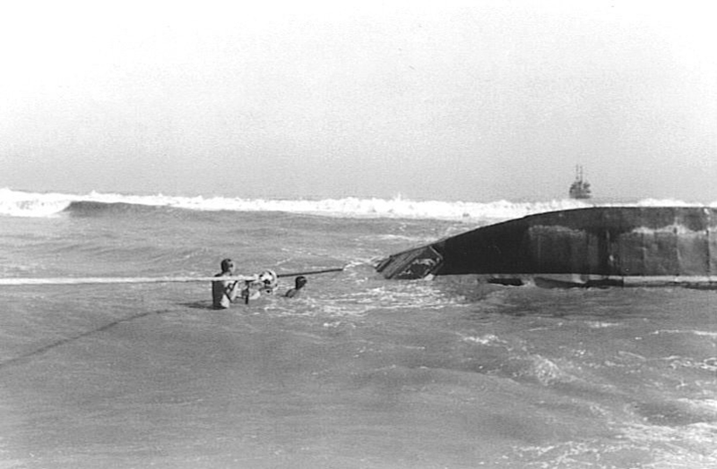 Photo of a U.S. Army LCU-63 capsized near Tan-My in November 1970. USS Cohoes (AN-78) is standing offshore. (U.S. Navy)